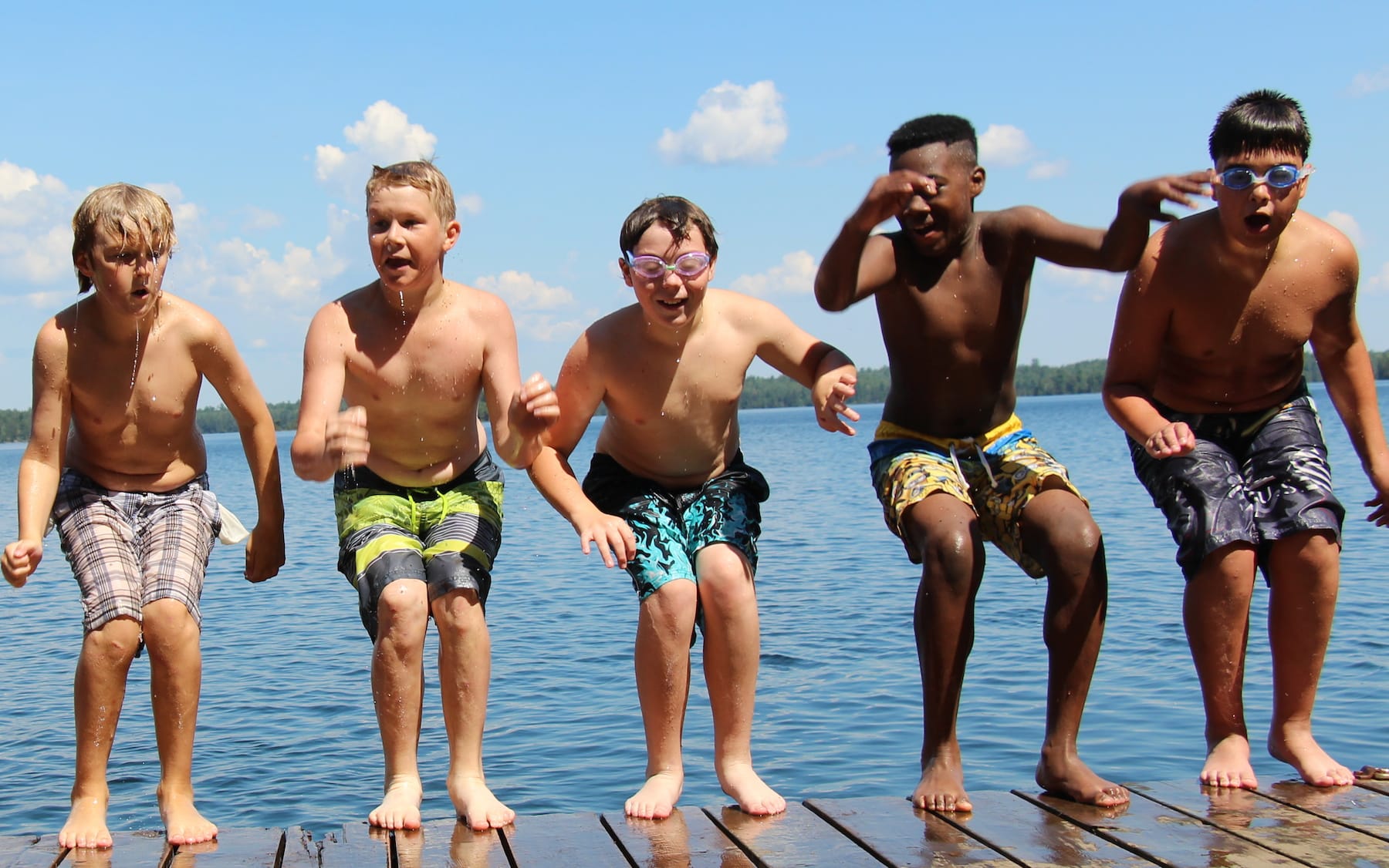 boys jumping off dock into water