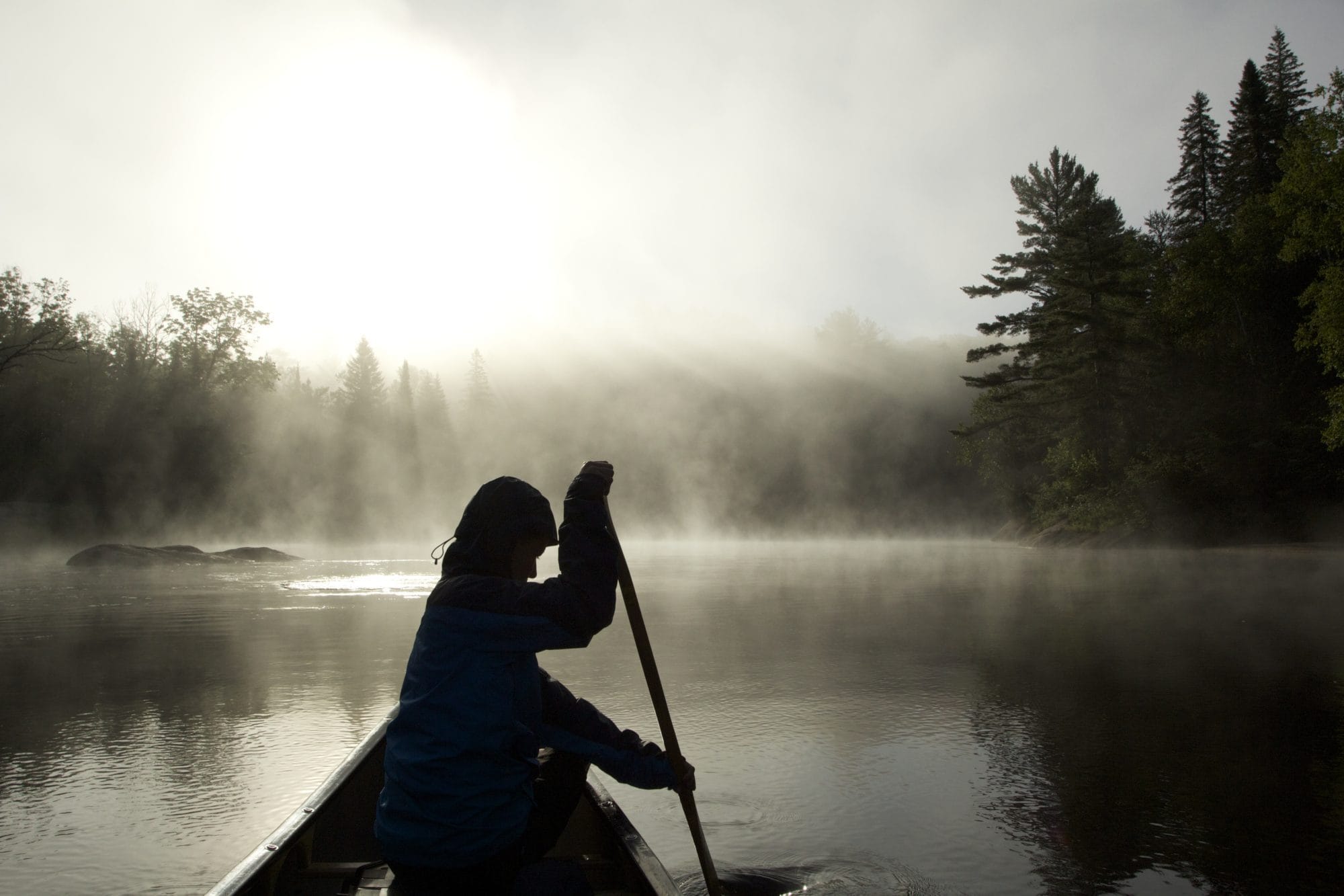 figure paddling in the mist